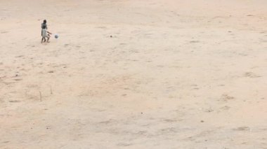KERALA, Hindistan - 21 Haziran 2024: Kumsalda top oynayan Hintli çocuklar. Yüksek kalite 4k görüntü