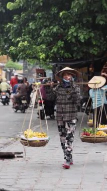Danang, Vietnam - 30 Haziran 2024 Danang, Vietnam 'da bir sokak pazarında saman şapkalı yaşlı kadın. Yüksek kalite 4k görüntü