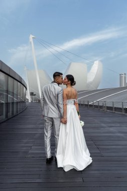 Bride and groom against the backdrop of the city of Singapore. Sunrise wedding photoshoot. . High quality photo clipart