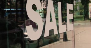 Bir alışveriş merkezinin camında beyaz harflerle 