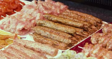 Yarı pişmiş et ürünleri. Ev ızgarasında pişirmek için soslu et hazırlıkları. Avrupa 'da mağaza tezgahı. Kebap, tavuk ve şiş için biftek. Parçalara ayrılmış et. Yüksek kalite 4k görüntü
