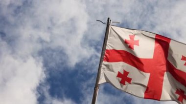 Rüzgarda sallanan gerçekçi Georgia bayrağı. Arka planı bulutlu. Mükemmel döngü. Yüksek kalite 4k görüntü