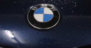 Berlin, Almanya... 10.04.2022 BMW logosu yeni bir arabanın kaputunda. Servis az önce arabayı yıkadı. Logonun etrafında su damlacıkları var. Yüksek kalite 4k görüntü