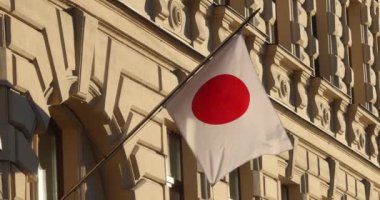 Bir Japon bayrağı Avrupa 'da bir duvarın önünde dalgalanıyor. Yüksek kalite 4k görüntü