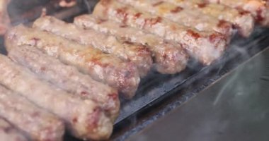 Birkaç lezzetli Bavyera et sosisi. Kızartma tavasında kabuklu sosisler ve sebze yağıyla mutfak maşası. Üst Manzara. Yakın plan. Yüksek kalite 4k görüntü