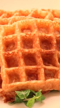 Spatula pişirmek, ev yapımı altın waffle 'ları mavi tabakta istiflemek, mutfakta kahvaltı hazırlamak. Yüksek kalite 4k görüntü