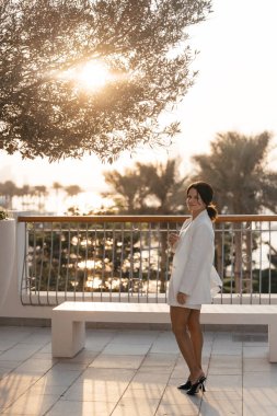 Dubai 'nin arka planına karşı beyaz takım elbiseli bir kadın. Yüksek kalite fotoğraf