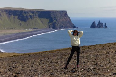 İzlanda 'da Vik plajı manzaralı bir uçurum boyunca koşan bir kız. Yüksek kalite fotoğraf
