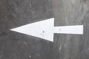 Solu gösteren büyük bir ok, asfalt yolda beyaza boyanmış. Şehirdeki yol işaretleri. Yüksek kalite fotoğraf