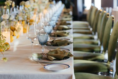 Yeşil peçeteli masalar, bardaklar, çiçekler ve sandalyeler. Peçetelerde özel klipler var. Restoran atmosferi. Yüksek kalite fotoğraf
