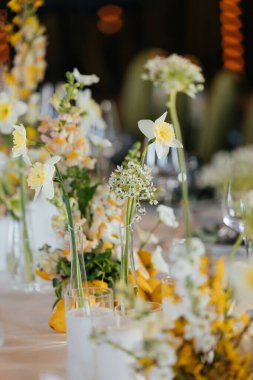 Masanın üzerinde güzel çiçekler ve bardaklardan oluşan bir kompozisyon. Yüksek kalite fotoğraf