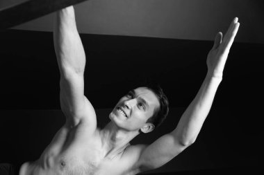 Zayıf erkek balerin pilates ekipmanlarıyla antrenman yapıyor. Zarif duruş, çekirdek gücü, vücut kontrolü. Yüksek kalite fotoğraf