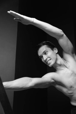 Zayıf erkek balerin pilates ekipmanlarıyla antrenman yapıyor. Zarif duruş, çekirdek gücü, vücut kontrolü. Yüksek kalite fotoğraf