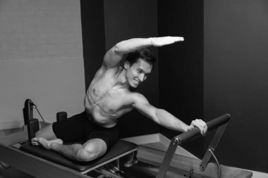 Zayıf erkek balerin pilates ekipmanlarıyla antrenman yapıyor. Zarif duruş, çekirdek gücü, vücut kontrolü. Yüksek kalite fotoğraf