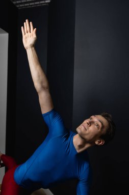 Zayıf erkek balerin pilates ekipmanlarıyla antrenman yapıyor. Zarif duruş, çekirdek gücü, vücut kontrolü. Yüksek kalite fotoğraf