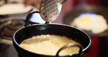 Zavallı pofuduk ekmek kızartma tavasında kızgın yağda kızartılır. Kızarmış, lezzetli ama sağlıksız, kötü kolesterol, LDL. Hintli bir şef mutfakta yemek pişiriyor, Puris yapıyor, lezzetli yemekler, sağlıksız...