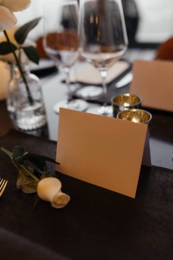 Masadaki beyaz gül ve boş kağıt kart. Metin için yeri olan minimalist çiçek kompozisyonu. Romantik, zarif ve doğal bir ortam. Kutlama, düğün ya da mesaj için. Yüksek kalite fotoğraf