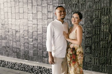 Irklar arası aşk yaşayan bir çiftin romantik yakın çekimi. Koyu tenli Asyalı adam ve zarif elbiseli Avrupalı esmer kadın. Aşk ve birlik, sonsuza dek birlikte. Yüksek kalite fotoğraf