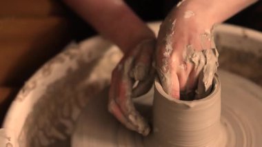 Zanaatkar bir stüdyoda çömlek çarkında çamurla çalışan ellerin yakın çekimi. Yaratıcı hobi, aktif seramik sanat ve özenli el işçiliği. Yüksek kalite 4k görüntü