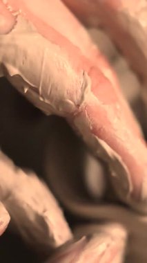 Zanaatkar bir stüdyoda çömlek çarkında çamurla çalışan ellerin yakın çekimi. Yaratıcı hobi, aktif seramik sanat ve özenli el işçiliği. Yüksek kalite 4k görüntü