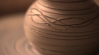 Zanaatkar bir stüdyoda çömlek çarkında çamurla çalışan ellerin yakın çekimi. Yaratıcı hobi, aktif seramik sanat ve özenli el işçiliği. Yüksek kalite 4k görüntü