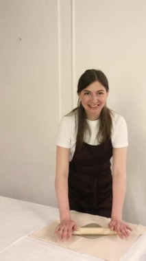  Sıcak çömlek atölyesinde kil yuvarlarken önlüklü gülümseyen kadın çömlekçi. Neşeli sanatsal hobi. Yüksek kalite 4k görüntü