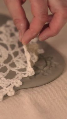 Çömlek atölyesinde el yapımı seramik Noel süslemeleri. Balçığa şenlik desenleri yerleştirmek için kumaş kar tanesi şablonu ve merdane kullanılıyor. Yaratıcı ve samimi bir tatil hazırlığı. Yüksek kalite 4k görüntü