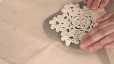 Çömlek atölyesinde el yapımı seramik Noel süslemeleri. Balçığa şenlik desenleri yerleştirmek için kumaş kar tanesi şablonu ve merdane kullanılıyor. Yaratıcı ve samimi bir tatil hazırlığı. Yüksek kalite 4k görüntü