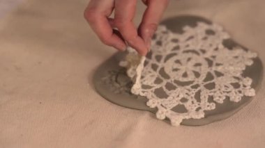 Çömlek atölyesinde el yapımı seramik Noel süslemeleri. Balçığa şenlik desenleri yerleştirmek için kumaş kar tanesi şablonu ve merdane kullanılıyor. Yaratıcı ve samimi bir tatil hazırlığı. Yüksek kalite 4k görüntü