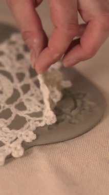 Çömlek atölyesinde el yapımı seramik Noel süslemeleri. Balçığa şenlik desenleri yerleştirmek için kumaş kar tanesi şablonu ve merdane kullanılıyor. Yaratıcı ve samimi bir tatil hazırlığı. Yüksek kalite 4k görüntü