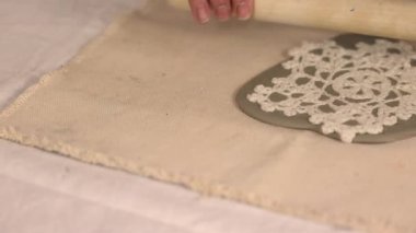 Çömlek atölyesinde el yapımı seramik Noel süslemeleri. Balçığa şenlik desenleri yerleştirmek için kumaş kar tanesi şablonu ve merdane kullanılıyor. Yaratıcı ve samimi bir tatil hazırlığı. Yüksek kalite 4k görüntü