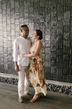 Irklar arası aşk yaşayan bir çiftin romantik yakın çekimi. Koyu tenli Asyalı adam ve zarif elbiseli Avrupalı esmer kadın. Aşk ve birlik, sonsuza dek birlikte. Yüksek kalite fotoğraf