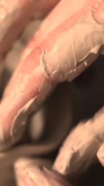Zanaatkar bir stüdyoda çömlek çarkında çamurla çalışan ellerin yakın çekimi. Yaratıcı hobi, aktif seramik sanat ve özenli el işçiliği. Yüksek kalite 4k görüntü
