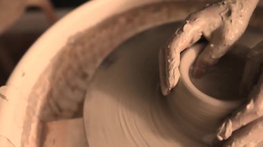 Zanaatkar bir stüdyoda çömlek çarkında çamurla çalışan ellerin yakın çekimi. Yaratıcı hobi, aktif seramik sanat ve özenli el işçiliği. Yüksek kalite 4k görüntü