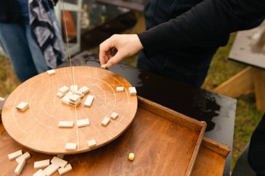 İplerinde işaretler olan tahta denge diski. Oyuncular blokları dengede tutmak için dikkatlice diske yerleştirirler. Motor beceriler, dikkat ve denge geliştirme için harika bir oyun.