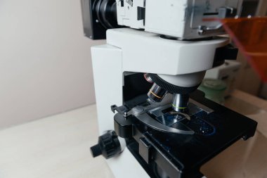 Tıbbi elektronik mikroskobun detaylı yakın çekimleri, bir sağlık ortamında laboratuvar analizi ve tanı araştırmasında kullanılan cam kaydırma üzerine odaklanmıştır.