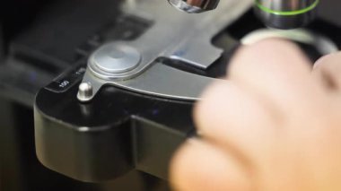 Tıbbi elektronik mikroskobun detaylı yakın çekimleri, bir sağlık ortamında laboratuvar analizi ve tanı araştırmasında kullanılan cam kaydırma üzerine odaklanmıştır.