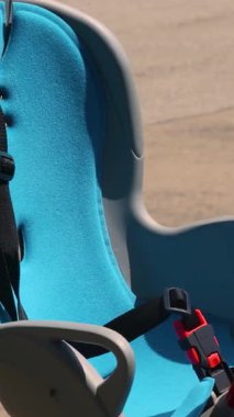 Açık havada parlak güneş ışığı altında bisiklete monte edilmiş mavi boş çocuk bisikleti koltuğu. Yüksek kalite 4k görüntü