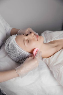 Doktor müşteriye kozmetik bir işlem uyguluyor. Yüksek kalite fotoğraf