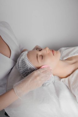 Doktor müşteriye kozmetik bir işlem uyguluyor. Yüksek kalite fotoğraf