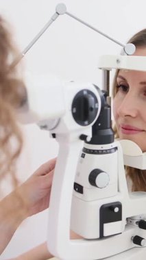 Klinikteki kadın doktor ve sarışın hastayla göz muayenesi. Yüksek kalite 4k görüntü