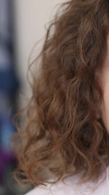 Klinikteki tıbbi mikroskoba bakarken gülümseyen kızıl saçlı kadın doktor. Yüksek kalite 4k görüntü