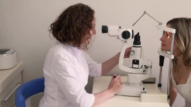 Klinikteki kadın doktor ve sarışın hastayla göz muayenesi. Yüksek kalite 4k görüntü