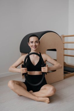 Merdiven namlusunda yüzükle pilates egzersizi yapan sportif bir kadın. Yüksek kalite fotoğraf