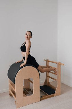 Pilates merdiveni fıçısı üzerinde pilates tonlama egzersizi yapan sportif bir kadın. Yüksek kalite fotoğraf