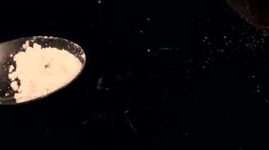 Yemek pişirmek için siyah arka planda un dolu kaşık. Yüksek kalite 4k görüntü