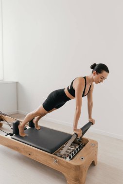 Pilates yenilikçi eğitim makinesi. Spor salonunda spor yapan bir kadın. Yüksek kalite fotoğraf