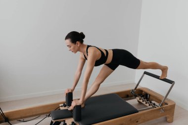 Pilates yenilikçi eğitim makinesi. Spor salonunda spor yapan bir kadın. Yüksek kalite fotoğraf