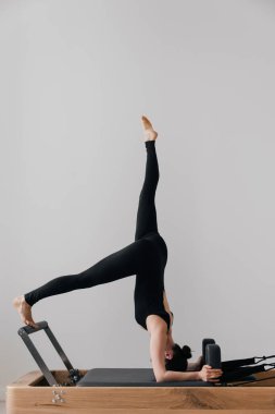Pilates yenilikçi eğitim makinesi. Spor salonunda spor yapan bir kadın. Yüksek kalite fotoğraf