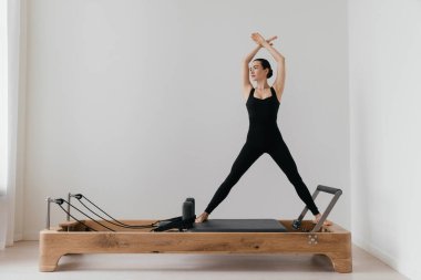 Pilates yenilikçi eğitim makinesi. Spor salonunda spor yapan bir kadın. Yüksek kalite fotoğraf
